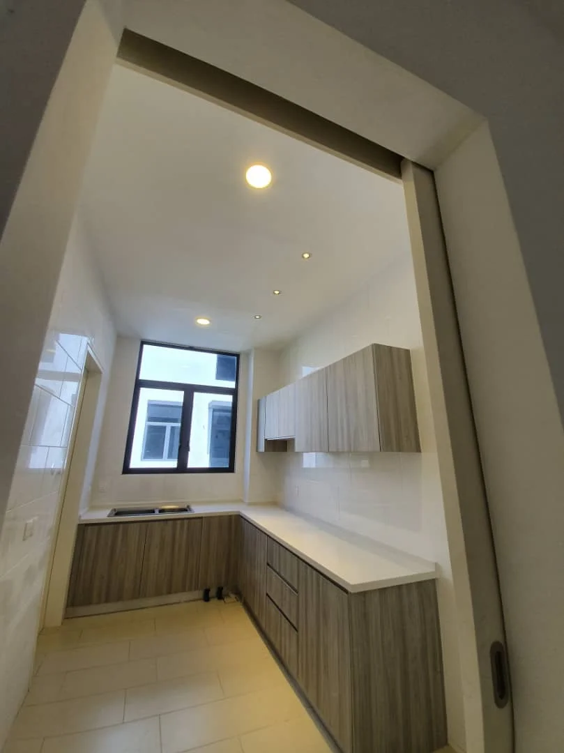 Kitchen features: laminate cabinetry in wood finish, white quartz countertop, single-bowl stainless-steel sink, chrome pull-down faucet, wall-mounted cabinets, tile backsplash, recessed downlights, large window for natural light, ceramic tile flooring, open layout; style: modern.